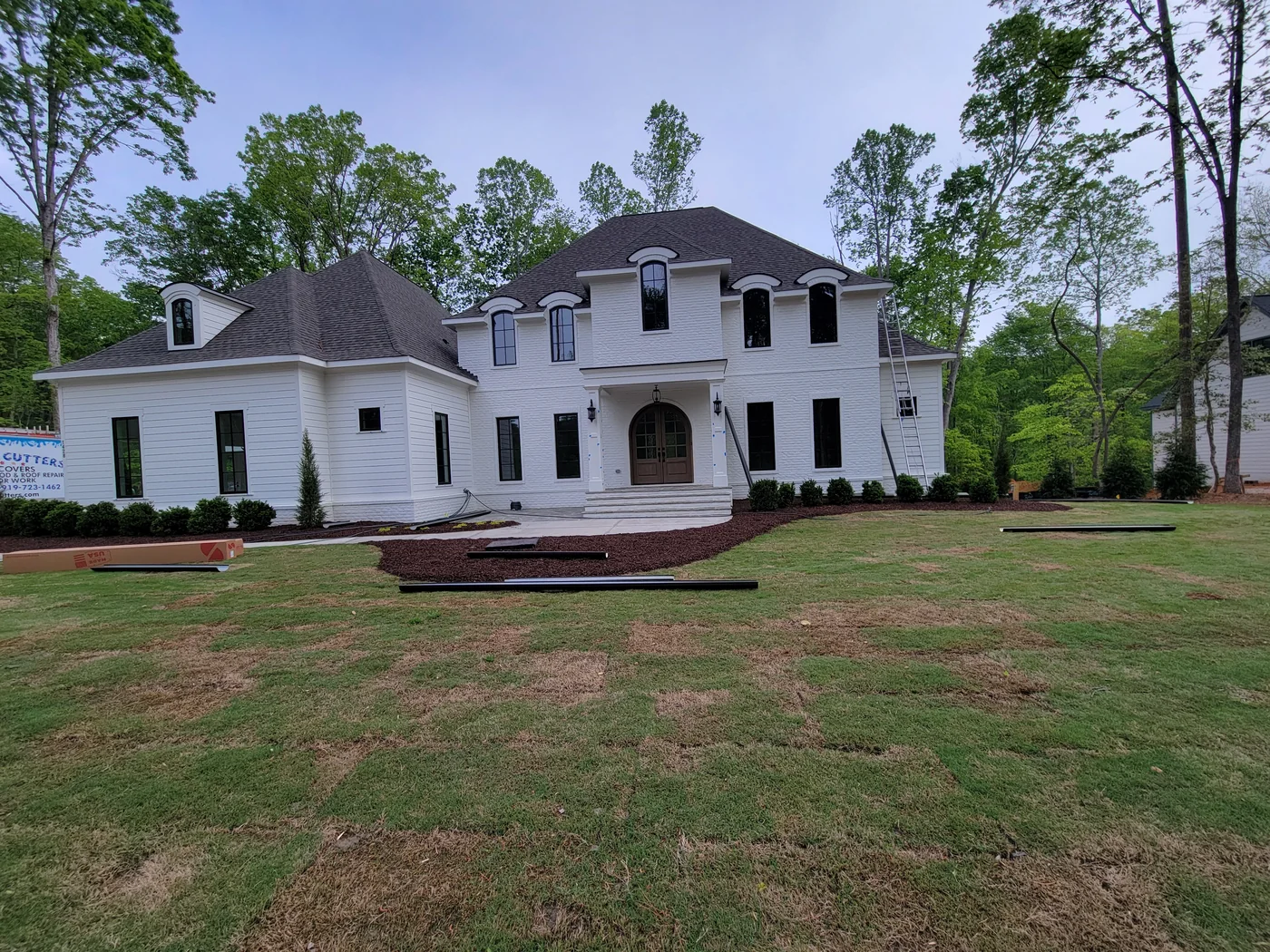 White Raleigh home with newly installed dark gutters from the SQH project gallery