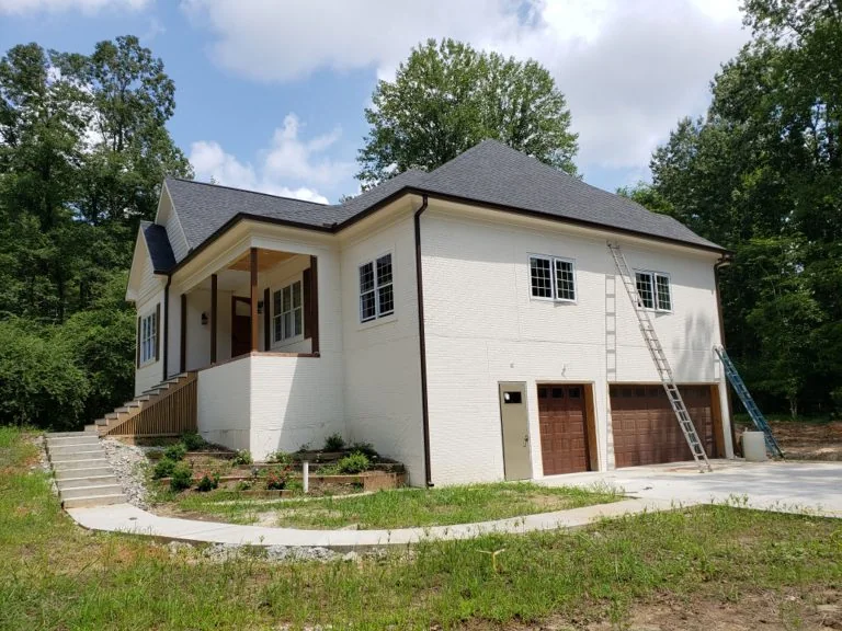Finished dark gutters on a white brick home
