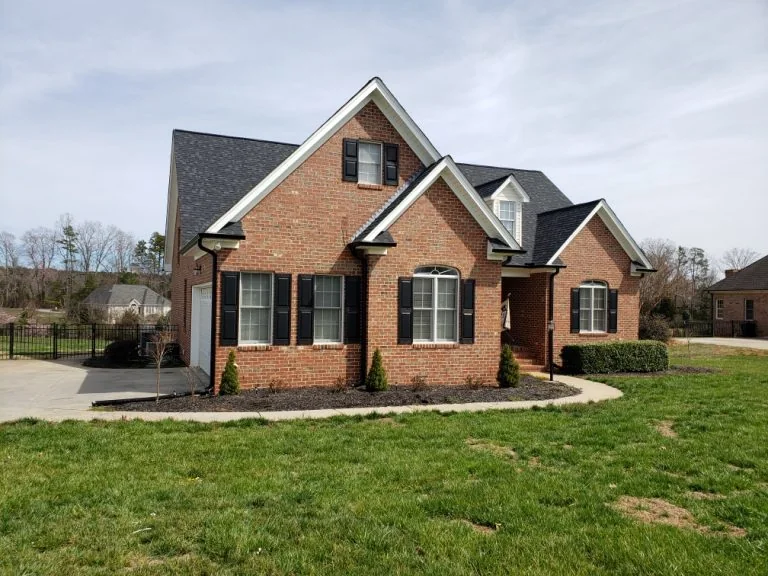 Finished dark gutters on a red brick home